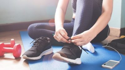 young woman tying shoe on sports mat royalty free image 1587302457