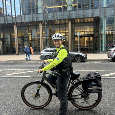 This image shows Constable Craig smiling on her bike in front of Grand Central Station.