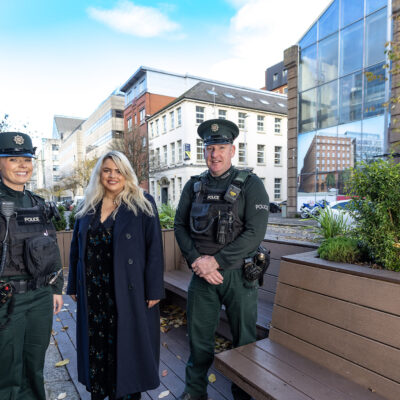 From left to right: Constable Craig, Linen Quarter BID's Finance and Contracts Officer, Charlotte, and Constable Rea stand on a parklet and smile at the camera.