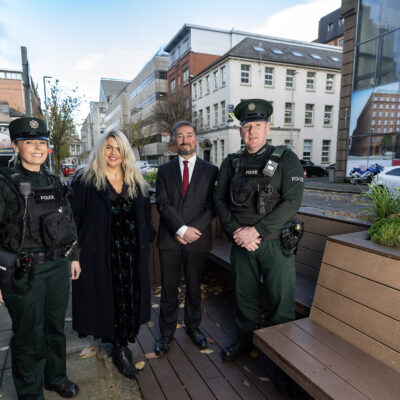 From left to right: Constable Craig, Linen Quarter BID's Finance and Contracts Manager, Charlotte, Linen Quarter's Managing Director, Chris, and Constable Rea, stand on a parklet smiling at the camera.