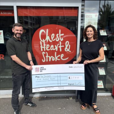 A man and a woman hold a giant cheque made out to Chest Heart & Stroke for £2500
